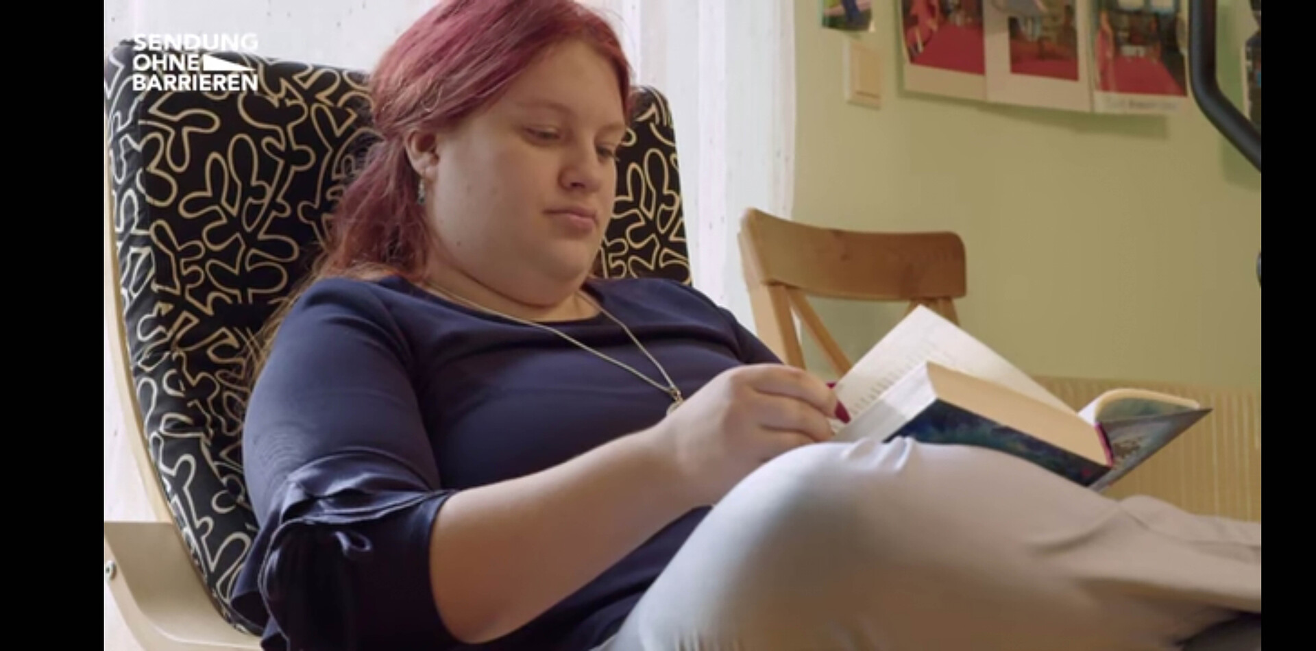 Eine junge Bewohnerin der WG Boltenstern sitzt in einem bequemen Sessel und liest ein Buch.
