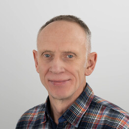 Mag. Andrej Rubarth Porträtaufnahme von Mag. Andrej Rubarth, Mitarbeiter der Fachstelle Wohnen bei BALANCE. Er blickt mit einem sanften Lächeln direkt in die Kamera. Er hat kurzes, hellbraunes bis graues Haar und trägt ein kariertes Hemd in Blau-, Orange- und Weißtönen vor einem neutralen, hellgrauen Hintergrund.