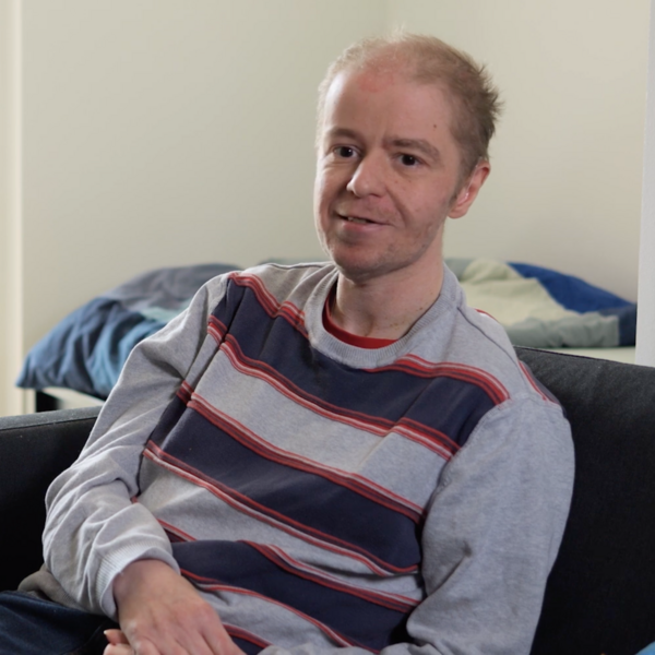 Ein Bewohner des Wohnverbunds K&auml;the Dorsch sitzt auf der Couch in seiner Wohnung.