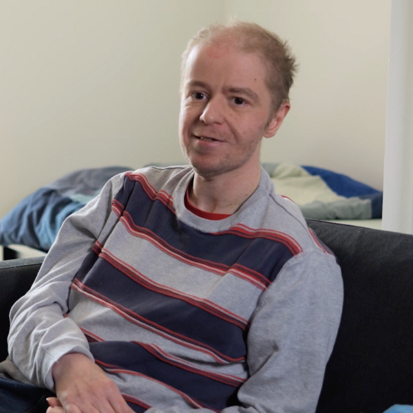 Ein Bewohner des Wohnverbunds K&auml;the Dorsch sitzt auf der Couch in seiner Wohnung.