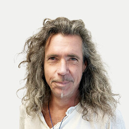 Portr&auml;taufnahme von Mag. Oliver Schweiger, Leitung der mobilen Dienste Mobi Zehn und Mobi 23 bei BALANCE. Er blickt mit einem freundlichen, offenen L&auml;cheln direkt in die Kamera. Er hat langes, lockiges und grau meliertes Haar sowie einen schmalen Kinnbart. Er tr&auml;gt ein wei&szlig;es Hemd und eine blaue Kette vor einem neutralen, hellen Hintergrund