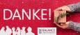 Schriftzug "DANKE!" zwei Hände halten ein Geschenkspaket, Logo von BALANCE