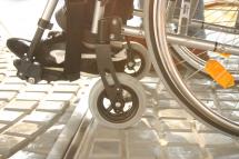 Rollstuhlfahrer beim Überqueren von Straßenbahnschienen
