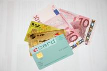 e-card, Kreditkarte, Kontokarte und zwei 10-Euro Scheine in einem Fächer aufgelegt